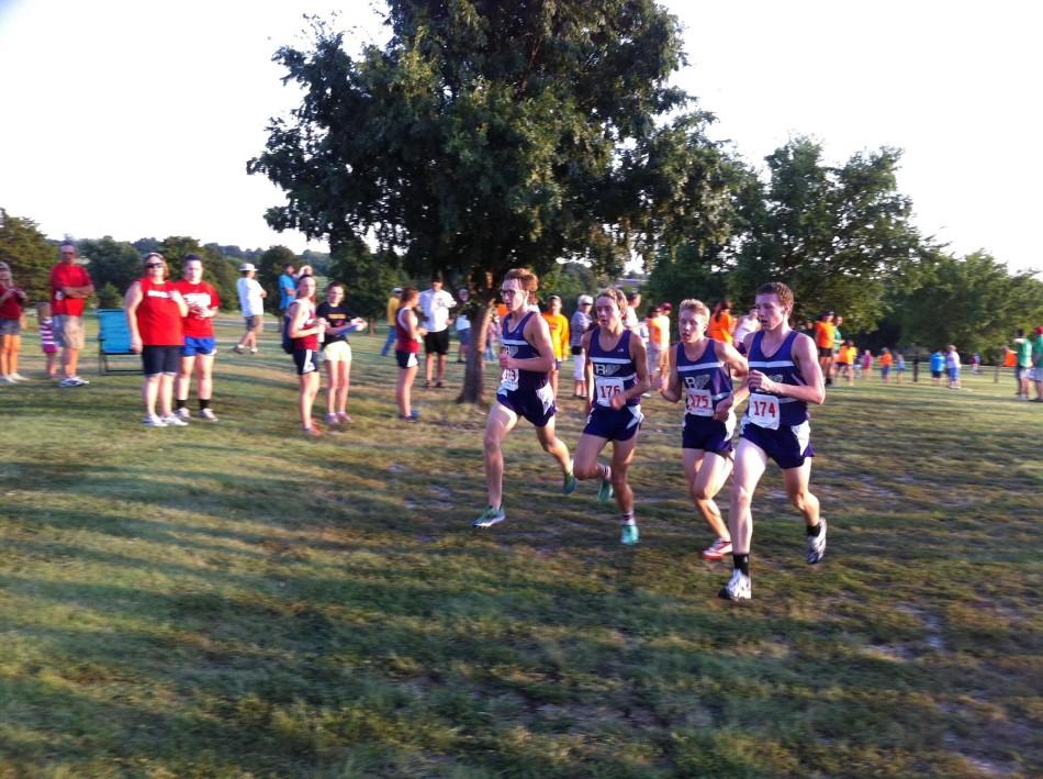 Boys cross country varsity runners prepare to cross the finish line at Anderson County